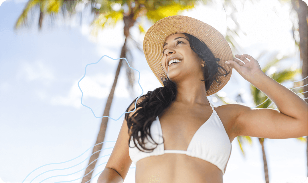 Happy woman in a swimsuit wearing a hat and bikini smiling and looking up after getting laser hair removal at her local Milan Laser clinic